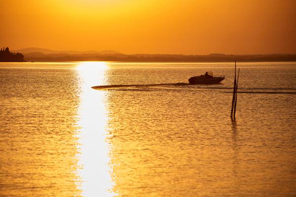 Goldgelbes Abendlicht am romantischen Lago Trasimeno See mit einem Boot from Robert Kalb
