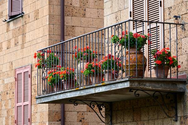 Romantischer Balkon mit roten Blumen in Tonkrügen from Robert Kalb